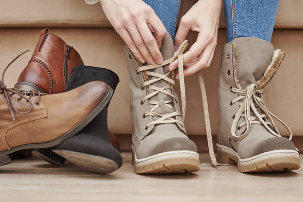 Γυναίκα επιλέγει άνετα παπούτσια ανάμεσα σε ένα μάτσο διαφορετικά ζευγάρια - Φωτογραφία, εικόνα