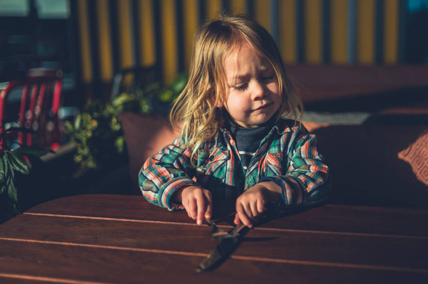 Little toddler sitting at cafe table with cutlery - Foto, immagini
