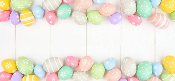 Pastel colored Easter Egg banner with double border against a white wood background. Above view with copy space. - Fotó, kép