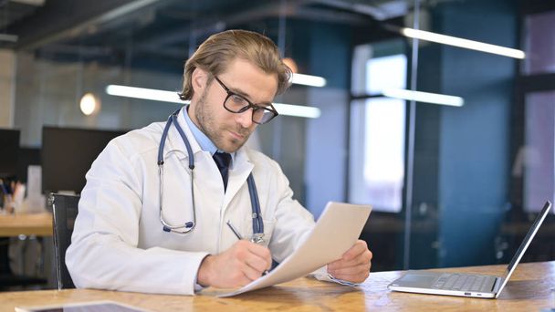 Arzt liest medizinische Dokumente in Klinik - Foto, Bild