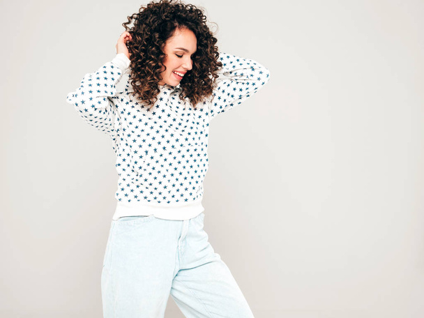 Portrait of beautiful smiling model with afro curls hairstyle dressed in summer hipster clothes.Sexy carefree girl posing in studio on gray background.Trendy funny and positive woman - Photo, Image