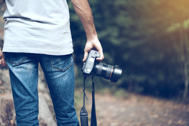 man hand camera in forest background  - Zdjęcie, obraz