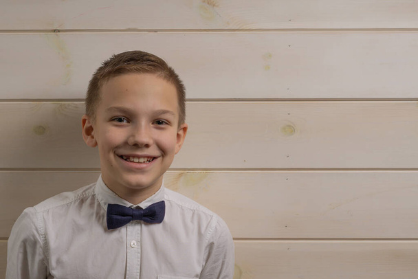Un garçon de 10 ans sourit sur le fond d'un w en bois
 - Photo, image