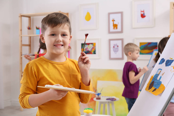 Cute little child painting during lesson in room - Photo, image