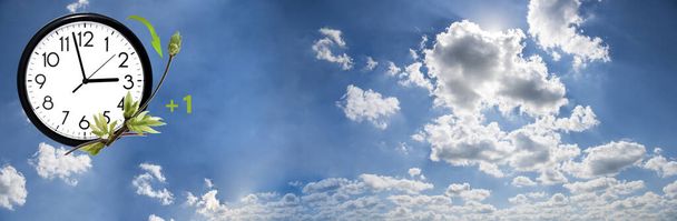 Zomertijd (Dst). Blauwe lucht met witte wolken en klok. Draai de tijd vooruit (+ 1 uur)). - Foto, afbeelding