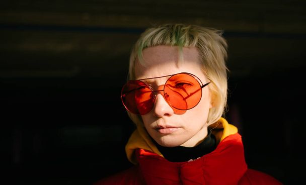Androgyne kadınının kırmızı güneş gözlüklü yakın çekimi - Fotoğraf, Görsel