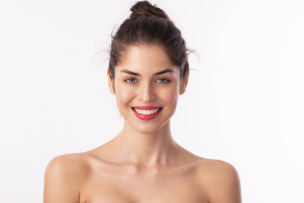 Крупный план красивой молодой женщины с зубастой улыбкой на красной помаде, позируя на изолированном белом фоне
.  - Фото, изображение