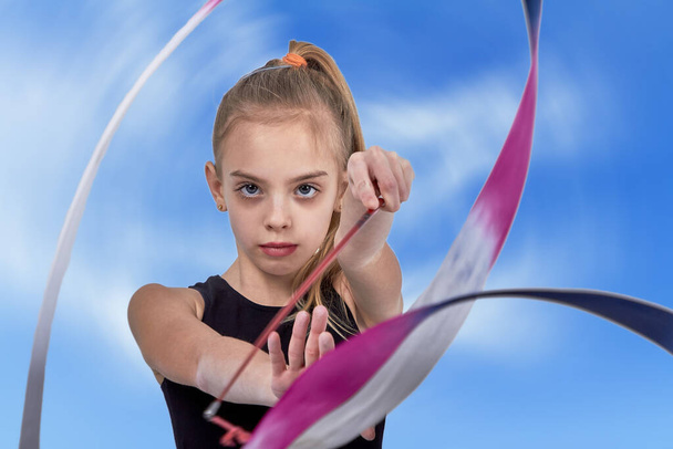 Young girl athlete with white hairstands with gymnastics ribbon - Valokuva, kuva