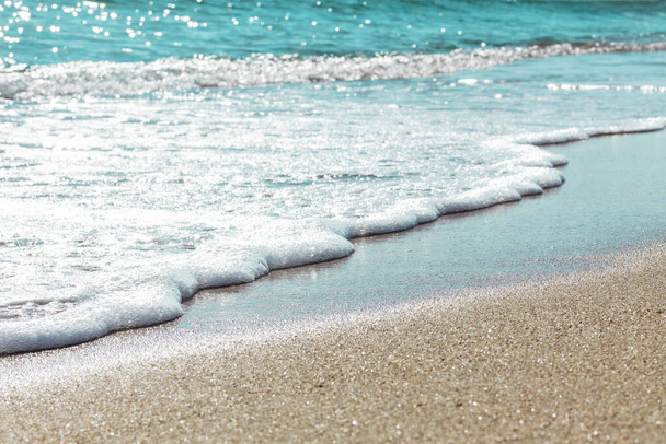 Background of sandy beach and foamed seawater in summer. - Photo, Image