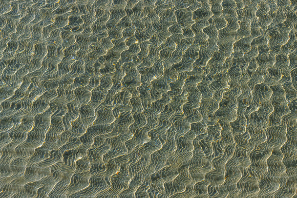 Ρηχό της θάλασσας σε αμμώδη παραλία κοντά. Όμορφα μαλακά κύματα, θαλάσσιο υπόβαθρο. - Φωτογραφία, εικόνα