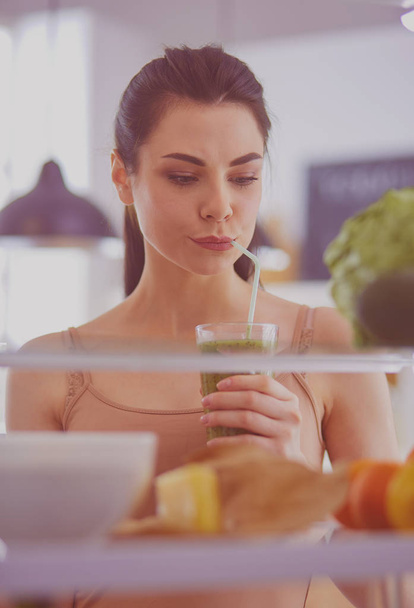 Young woman with glass of tasty healthy smoothie at table in kitchen - Foto, immagini