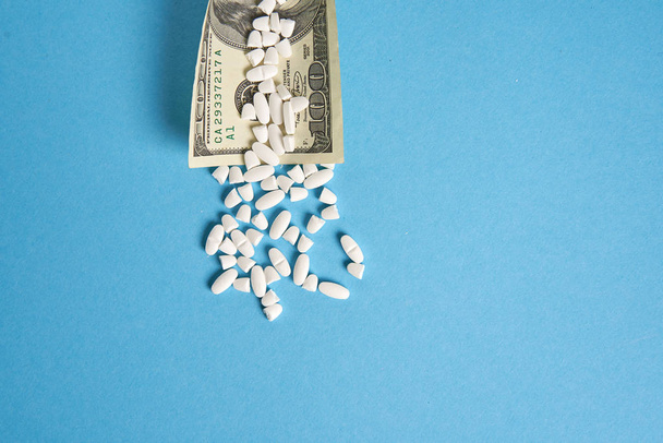 pills empty blisters for drugs individual syringe and money lie on a blue background - Valokuva, kuva