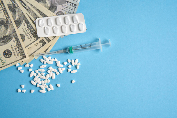 Prášky prázdné blistry na drogy jednotlivé injekční stříkačky a peníze leží na modrém pozadí - Fotografie, Obrázek
