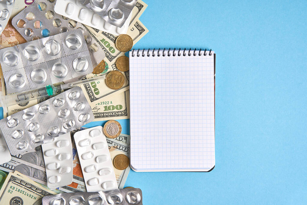 pastillas ampollas vacías para las drogas jeringa individual y dinero se encuentran en un fondo azul
 - Foto, Imagen