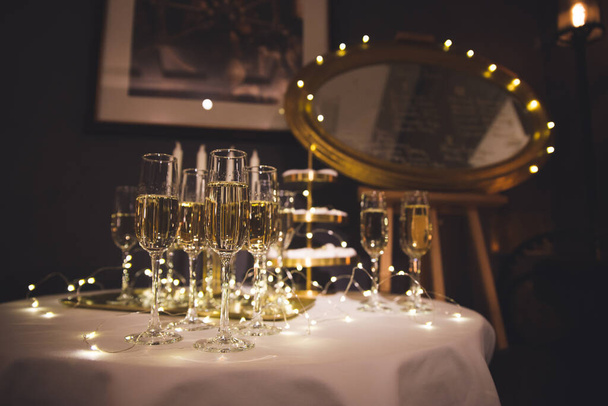 Two glasses of champagne with lights in the background. very shallow depth of field, focus on near glass. - Φωτογραφία, εικόνα