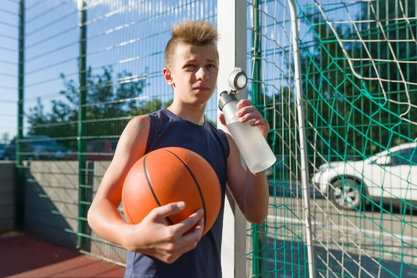 Garçon adolescent joueur de basket avec boule d'eau potable de la bouteille
 - Photo, image