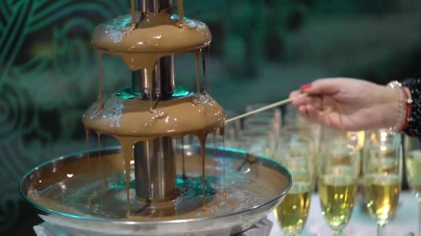 Dipping fruits to liquid chocolate fountain fondue - Séquence, vidéo