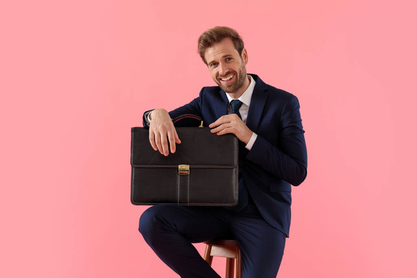 Positive businessman holding a briefcase and laughing  - Φωτογραφία, εικόνα