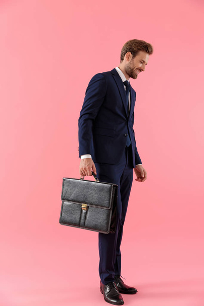 Happy businessman holding a briefcase and laughing - Foto, afbeelding