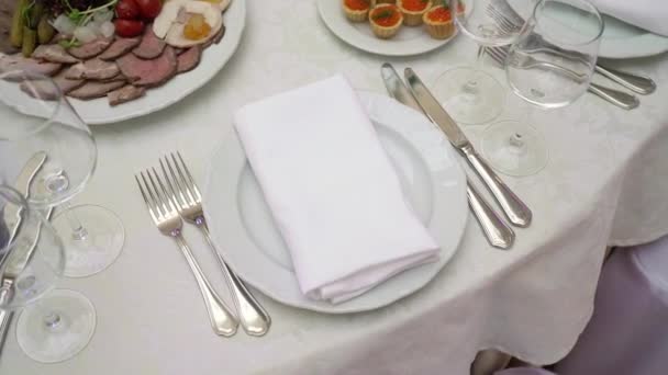 Glasses, plates and napkins in the restaurant. A covered table for a party - Filmagem, Vídeo