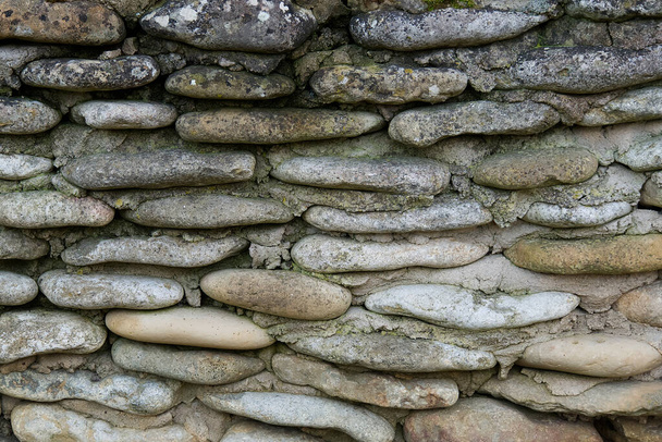 Fragment of an old wall of gray stone blocks. The stones are flat and rough. Background. Texture. - Photo, Image
