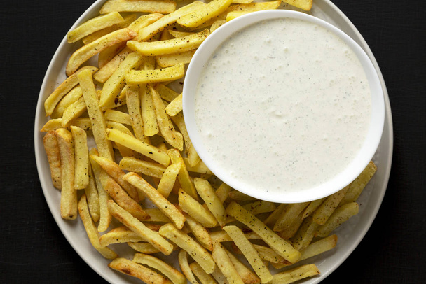 Homemade Crispy Ranch Fries on black surface, top view. Flat lay - 写真・画像