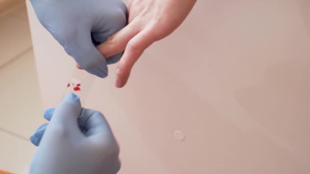 Тест крові медсестра приймає кров від молодих дівчат пальцем ставлячи його на скло ВІЛ
 - Кадри, відео