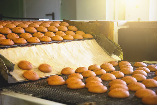 Ipari élelmiszer-előállítás. Gyári vagy pékipari szállítószalag süteményekkel. Automatizálási gyártás - Fotó, kép