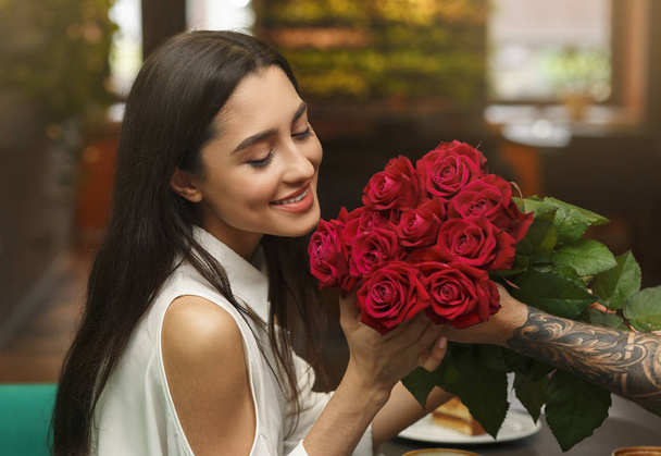 Mulher feliz recebendo buquê de seu namorado amoroso no café
 - Foto, Imagem