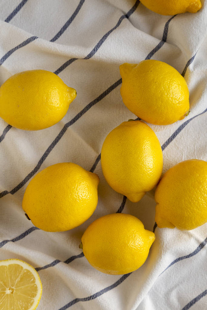 Спелые желтые органические лимоны на ткани, вид сверху. Плоский лежал, чтобы
 - Фото, изображение