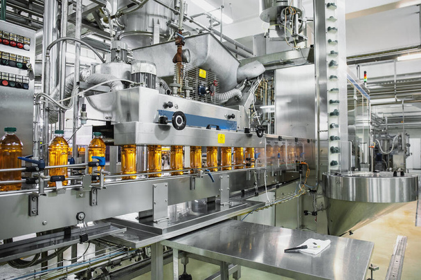 Βιομηχανικό εσωτερικό της παραγωγής φυσικών χυμών. Ζώνη μεταφοράς, γεμιστά μπουκάλια σε εργοστάσιο ποτών, γραμμή παραγωγής της βιομηχανίας - Φωτογραφία, εικόνα
