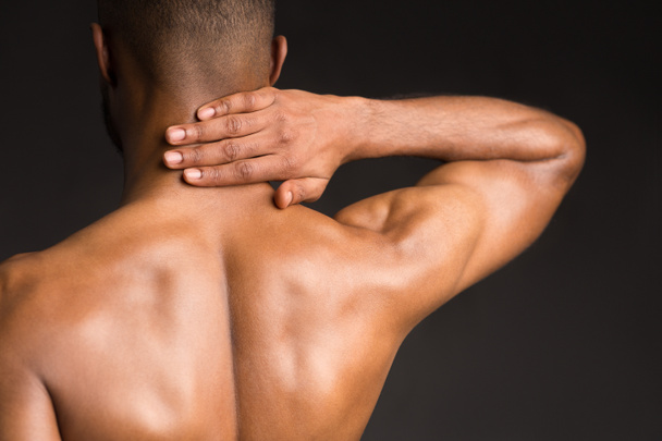 Hombre negro sin camisa que sufre de dolor en el cuello
 - Foto, Imagen