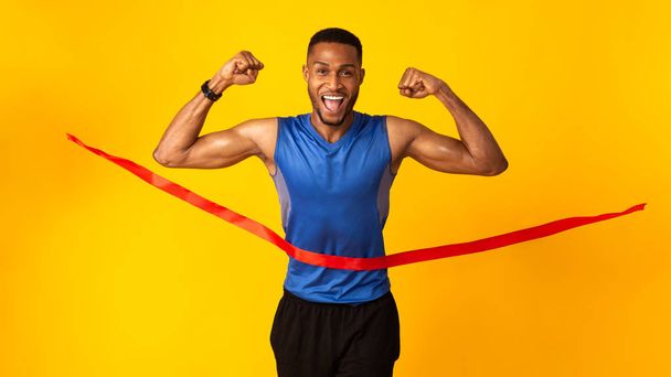 Homem negro feliz celebrando sucesso quebrando corda de acabamento
 - Foto, Imagem