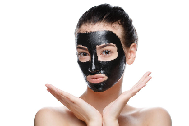 girl with black cosmetic mask on face posing - Foto, afbeelding