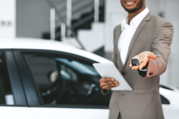Unbekannter Verkäufer bietet Autoschlüssel im Autohaus-Center an, abgeschnitten - Foto, Bild