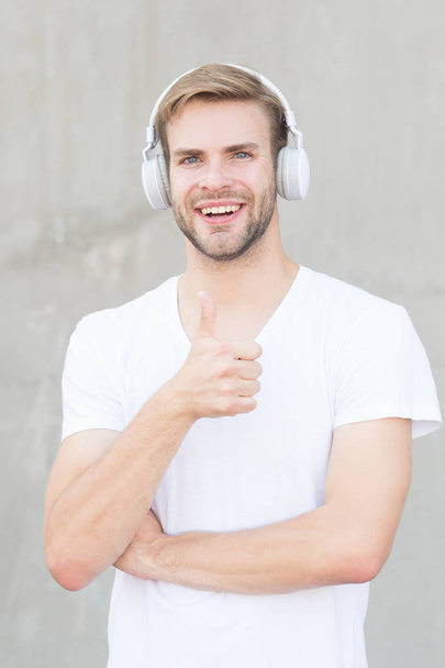 Wireless Earpiece. Handsome guy wear headphones grey background. Man listen modern music. Modern technology. Modern and contemporary music. Hobby leisure. Foldable Stereo Headphones. Noise Reduction - Photo, Image