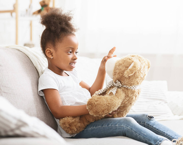 entzückendes schwarzes kleines Mädchen spielt zu Hause mit Spielzeug - Foto, Bild