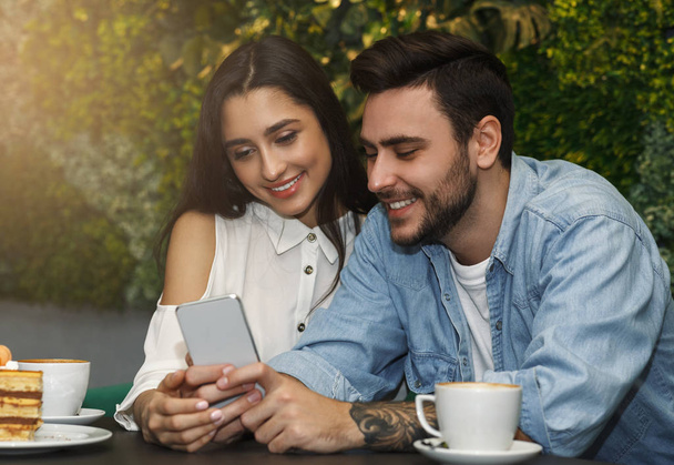 Paar met behulp van Smartphone met koffie zitten in Cafe - Foto, afbeelding