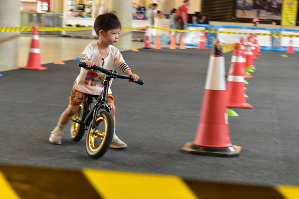 παιδί παίζει ισορροπία ποδήλατο στον ιππόδρομο, ταχύτητα κίνησης θόλωμα εικόνα - Φωτογραφία, εικόνα