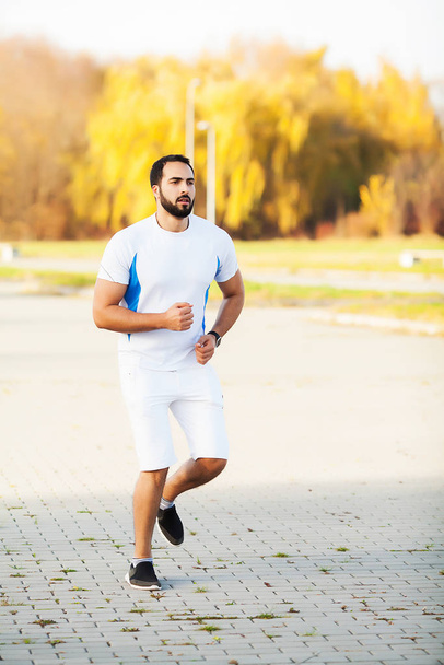 Fit muscular man running and doing exercise outside - Foto, Imagem