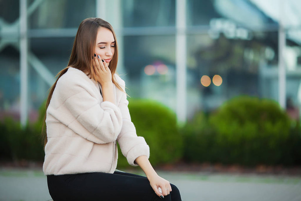 Woman stressed from work while sitting outdoors - Foto, Imagen