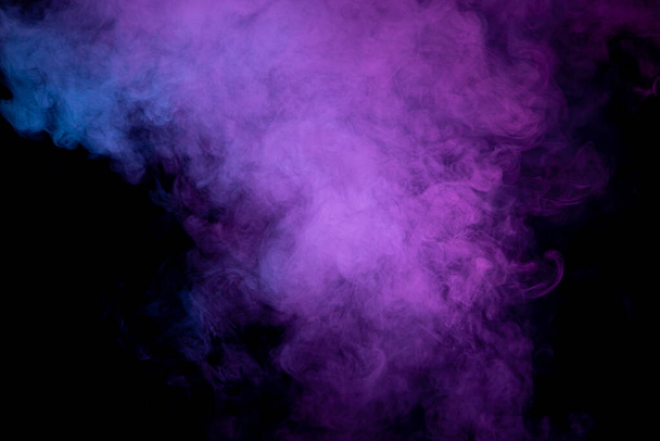 Espeso humo colorido de color rosa, azul sobre un fondo negro aislado. Fondo del humo del vapor
 - Foto, Imagen