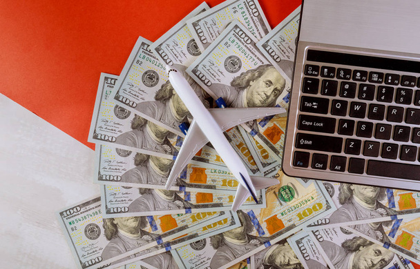 Τραπεζογραμμάτια αμερικανικού δολαρίου με πλαστικό μοντέλο αεροπλάνου και πληκτρολόγιο υπολογιστή - Φωτογραφία, εικόνα