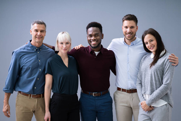 Group Of Young Successful Multi-ethnic Businesspeople Standing In Office Looking At Camera - Foto, Imagen