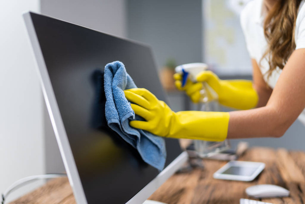 Young Worker Cleaning Desk With Rag In Office - Photo, image