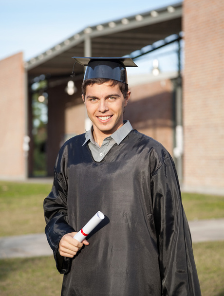 Graduate Student Holding Diploma On Graduation Day At Campus - Foto, Imagen