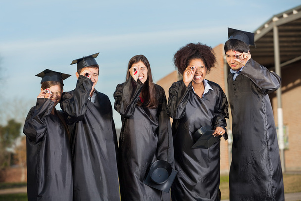 afgestudeerde studenten op zoek via diploma's op de campus - Foto, afbeelding