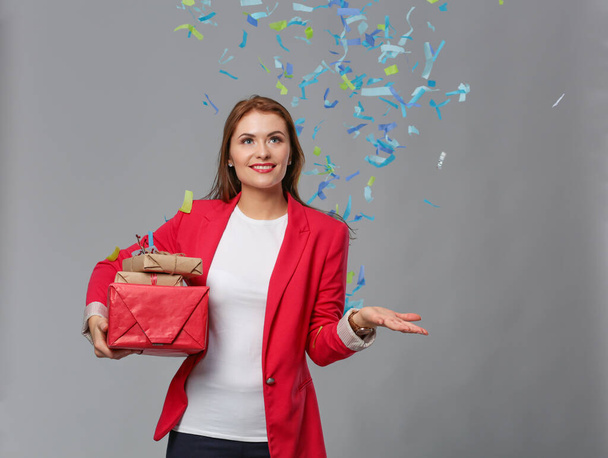 Beautiful happy woman with gift box at celebration party with confetti . Birthday or New Year eve celebrating concept - Fotó, kép