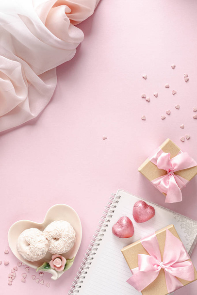 Cadeaudoosje of geschenkdoosje en bloemen op roze tafelblad. Plat gelegd. Verjaardag, bruiloft, Valentijnsdag, 8 maart concept. kopieerruimte - Foto, afbeelding