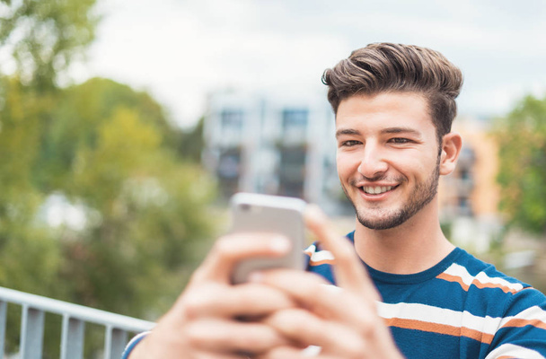 Happy  young man making a photo with his mobile phone - Фото, зображення